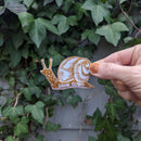 Iron-on patch | slow down snail - brown 1.6" x 2.6": Patch attached to backer card
